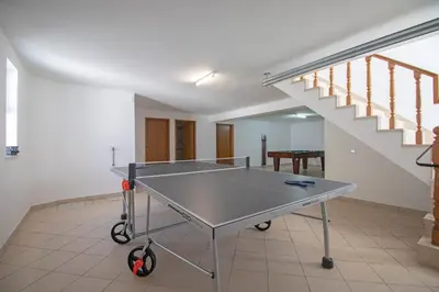 a ping pong table in a room with a staircase at Villa Azul in Guia