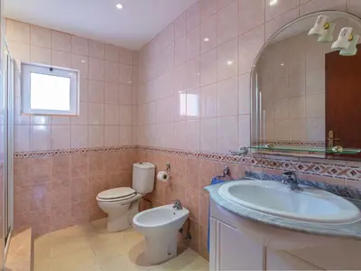 a bathroom with a sink and a toilet and a mirror at Villa Villa Rosa by Interhome in Loulé