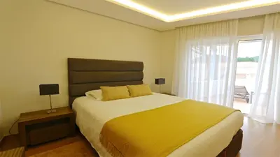 a bedroom with a large bed with a yellow blanket at Villa Pinhal 213-CleverDetails- Sleeps 8, Quiet area, walking distance in Vilamoura