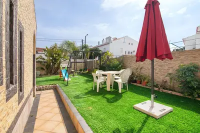a garden with a table and chairs and an umbrella at T2 Anastácio com vista Piscina in Olhos de Água