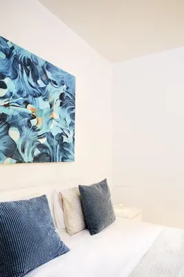 a bedroom with a bed with a painting on the wall at Casas Barulho Albufeira Marina in Albufeira