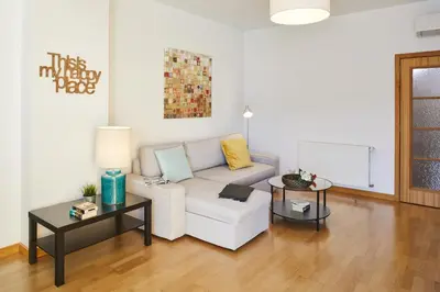 a living room with a white couch and two tables at Casas Barulho Albufeira Marina in Albufeira