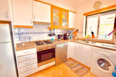 a kitchen with white cabinets and a sink and a dishwasher at Estrada de, Urbanizacao,edificio laranjal,apartment 18,vale carro, 8200-596 in Albufeira