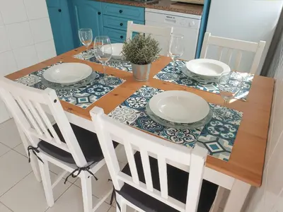 a dining room table with plates and wine glasses at Casa Albufeira in Albufeira