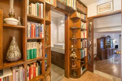 a library with wooden shelves filled with books at Apartamento Avenida da Liberdade in Albufeira