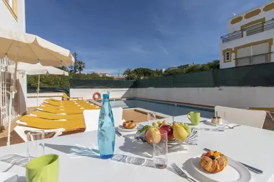 a table with a bottle of water and fruit on it at Villa Pacheco in Albufeira