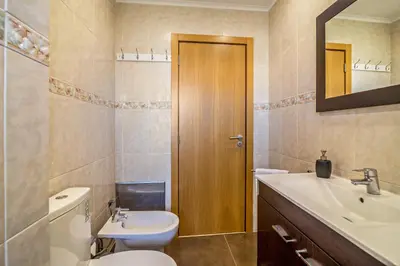 a bathroom with a toilet and a sink and a mirror at Vilamoura Boutique Apartment in Quarteira