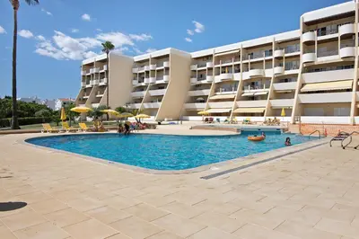 a swimming pool in front of a building at Palmeira Galé in Galé