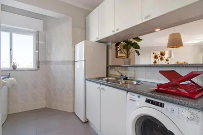 a kitchen with a washing machine and a sink at Palmeira Galé in Galé