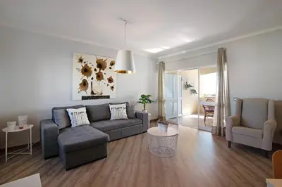 a living room with a couch and a table and chairs at Palmeira Galé in Galé