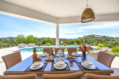 a dining room with a table and chairs and a pool at Private Oasis in Algarve with Pool & Fruit Garden in Loulé
