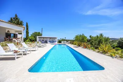 a swimming pool with chairs and a villa at Private Oasis in Algarve with Pool & Fruit Garden in Loulé