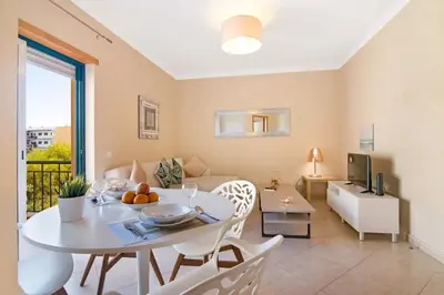a white living room with a table and a couch at Almancil Park Apartment in Almancil