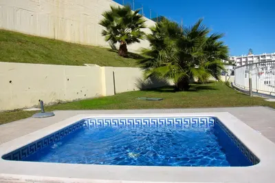 a swimming pool in a yard with palm trees at Duplex Varandas Do Mar Patricia Vista Mar - 50 metros Praia Olhos de Água in Albufeira