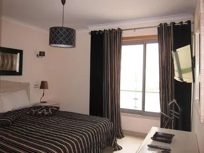 a hotel room with a bed and a window at Duplex Varandas Do Mar Patricia Vista Mar - 50 metros Praia Olhos de Água in Albufeira