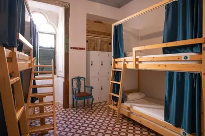 a room with two bunk beds and a ladder at Tilia Hostel in Faro