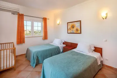 a bedroom with two beds and a crib at GR 2 X Private Villas Private Pools - Up to 20 Guests in Albufeira