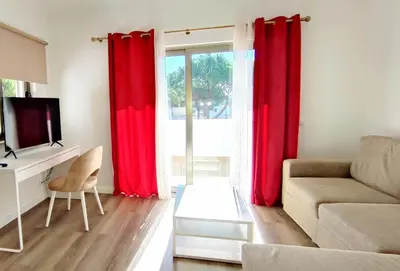 a living room with red curtains and a couch at 6 Bedroom Private Villa Tenazinha I, with private pool in Albufeira