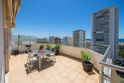 a balcony with a table and chairs on a balcony at Stylish Algarve Apartment with Spacious Terrace & Sea Views in Quarteira