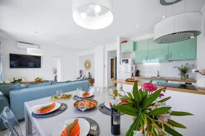 a kitchen and living room with a table with food on it at Stylish Algarve Apartment with Spacious Terrace & Sea Views in Quarteira