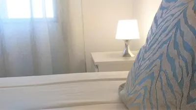 a bedroom with a bed with a pillow and a lamp at T1 Torre 17 Vista Cidade in Quarteira