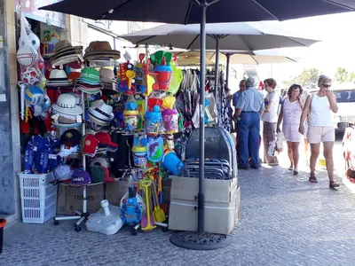a group of people walking around a market with hats at T1 Torre 17 Vista Cidade in Quarteira