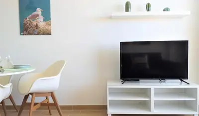 a flat screen tv sitting on a white tv stand at T1 Mira Praia 7 - Remodelado, Ar-Condicionado, Vista Mar, Wifi in Quarteira
