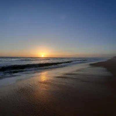 a sunset on a beach with the ocean at Quinta do Lago Villa and Golf in Quinta do Lago