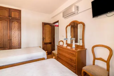 a bedroom with a bed and a dresser and a mirror at Regueiró Quarteira Beach Apartment in Quarteira
