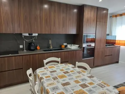 a kitchen with a table and chairs in a kitchen at Regueiró Quarteira Beach Apartment in Quarteira