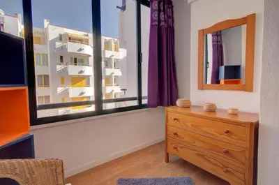 a bedroom with a dresser and a large window at AL - Apartamento 1021 Impervilla in Quarteira