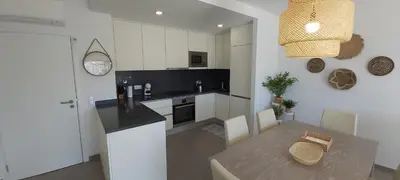 a kitchen with a table and a dining room at Albufeira beach apartment in Albufeira
