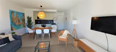 a living room with a couch and a dining room at Albufeira beach apartment in Albufeira