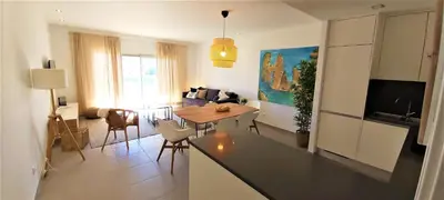 a kitchen and living room with a table and a couch at Albufeira beach apartment in Albufeira