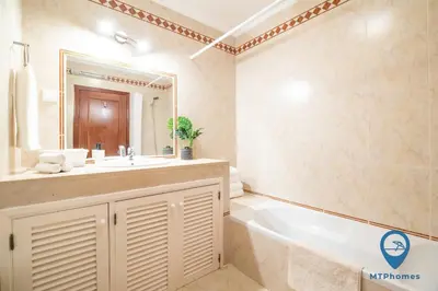 a bathroom with a tub and a sink and a mirror at Vila Nico by MTPhomes in Albufeira