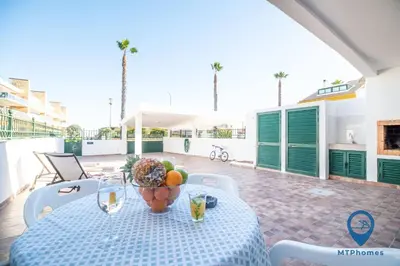 a table with a bowl of fruit and glasses on a patio at Vila Nico by MTPhomes in Albufeira