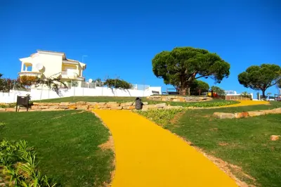 a yellow path in front of a white house at Heated Pool 6 Bedroom Private Villa in Center of Olhos de Água in Albufeira