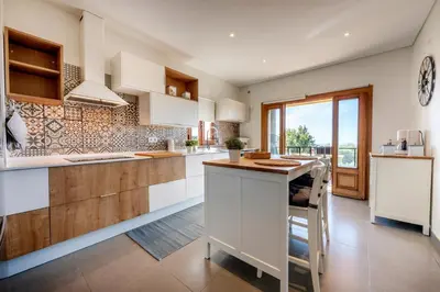 a kitchen with white cabinets and a counter top at Sunny House in Loulé