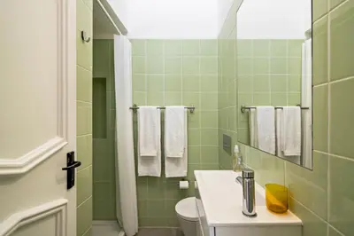 a green bathroom with a sink and a toilet at Casa O12 in Vilamoura
