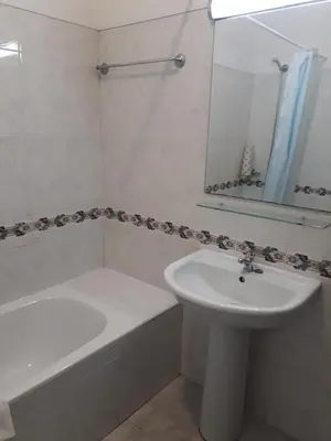 a white bathroom with a sink and a tub and a mirror at cantinho do mar in Albufeira