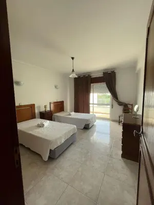a large room with two beds and a large window at cantinho do mar in Albufeira