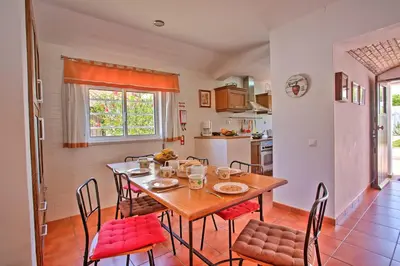 a kitchen and dining room with a table and chairs at Villa Dela by Villa Plus in Albufeira