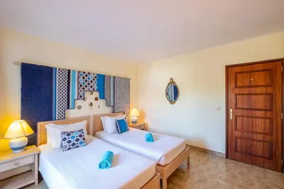 a bedroom with two beds with blue pillows at Carolina Sea Apartment in Albufeira