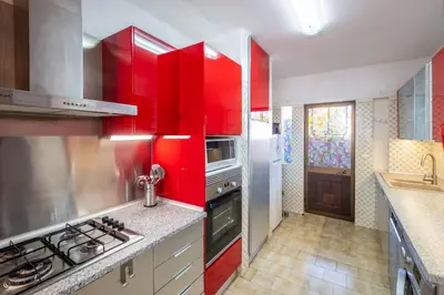 a kitchen with red cabinets and a stove at Carolina Sea Apartment in Albufeira
