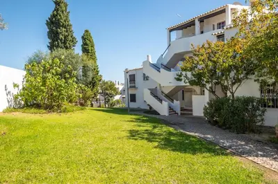 a building with a grassy yard in front of it at Carolina Sea Apartment in Albufeira