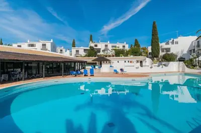 a swimming pool with blue water in a resort at Carolina Sea Apartment in Albufeira