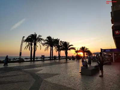 a group of people walking on a beach at sunset at Alsol C 5361-1 in Quarteira
