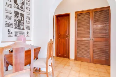 a dining room with a table and a wooden door at LovelyStay - Villa Mimi in Vilamoura