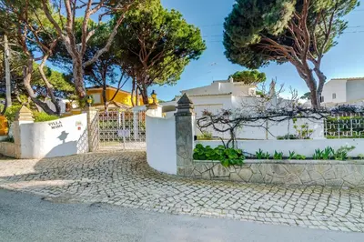 a white fence with trees in the background at LovelyStay - Villa Mimi in Vilamoura