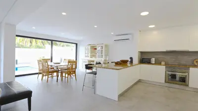 a kitchen with white cabinets and a table with chairs at Marina Parque 211-CleverDetails, Located in the Marina, Private Pool in Vilamoura